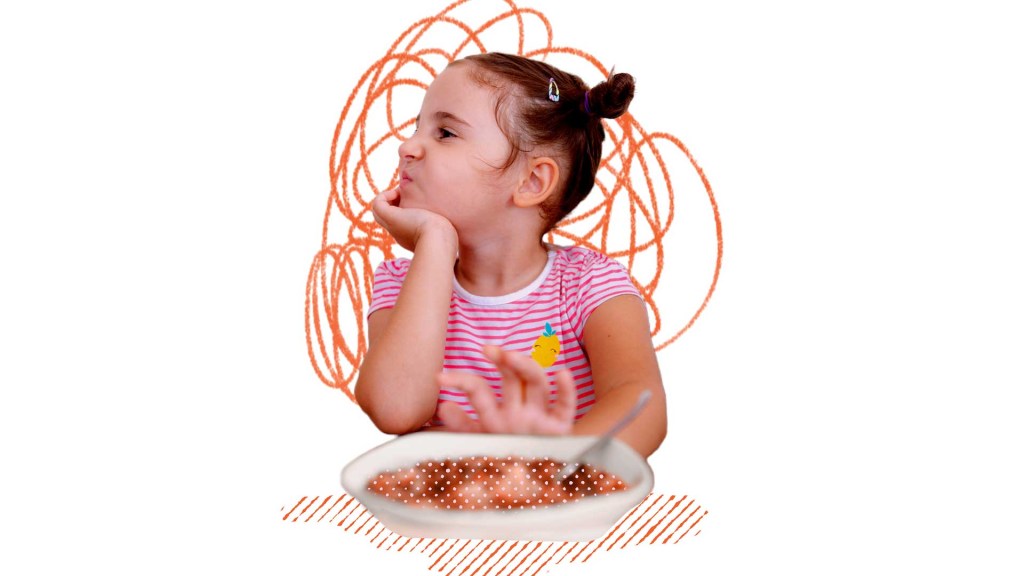 menina fazendo careta diante de um prato de comida